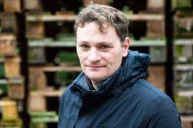 45 yo male posing in a winter jacketwith a wooden pallet background, Koekelberg, Brussels, Belgium. Model released clipart