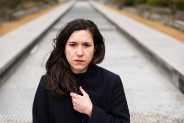 Açık havada, şehirde uzun bir merdivende oturan kahverengi saçlı 28 yaşında beyaz bir kadının portresi. Model bırakıldı