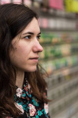 Çekici bir esmerin, şehrin renkli bir duvarına karşı poz verirken yarı vücut pozu. Model bırakıldı