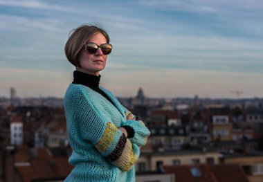 Belçika 'nın Brüksel şehrinin çatısında güneş gözlüklü çekici, beyaz bir kadının portresi. Model bırakıldı