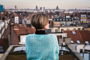 Belçika 'nın Brüksel şehrinin çatısında güneş gözlüklü çekici, beyaz bir kadının portresi. Model bırakıldı