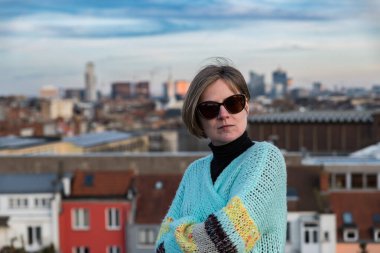 Belçika 'nın Brüksel şehrinin çatısında güneş gözlüklü çekici, beyaz bir kadının portresi. Model bırakıldı