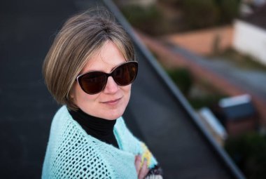 Belçika 'nın Brüksel şehrinin çatısında güneş gözlüklü çekici, beyaz bir kadının portresi. Model bırakıldı