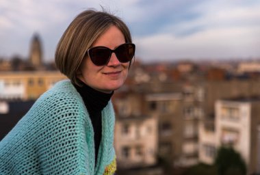 Belçika 'nın Brüksel şehrinin çatısında güneş gözlüklü çekici, beyaz bir kadının portresi. Model bırakıldı