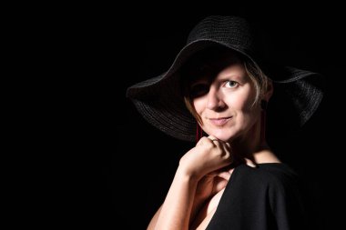 Stüdyoda siyah şapkalı beyaz bir kadın poz veriyor. Brüksel, Belçika. Model bırakıldı