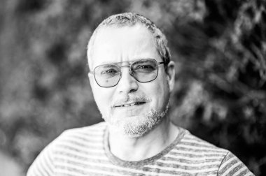 49 yaşındaki gözlüklü ve sakallı bir adamın portresi Ternat 'ta yeşil arka planda, Flaman Brabant, Belçika Modeli