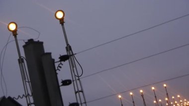 Foggy Havaalanı Parıltısı. Bu video gündoğumundan hemen önceki anı bir havaalanı pistinin kenar mahallelerinde yakalıyor. Parlayan bir ışık çizgisi gerilir, şafak sisinin içinden yumuşak ışınlar saçar ve rüya gibi bir efekt yaratır..