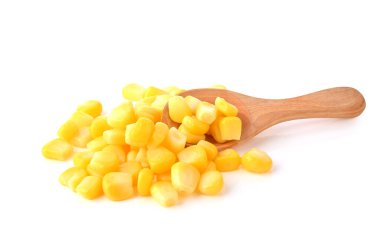 Beyaz arka planda tahta kaşıkta tatlı mısır tohumları yığını.