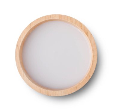 Ahşap kasedeki hindistan cevizi sütü beyaz arka planda izole edilmiş yapışkan pirincin üzerine dökülmesi için. en üstteki görünüm