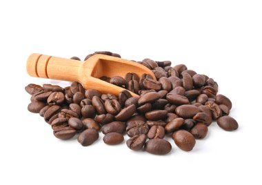 Beyaz arka planda izole edilmiş ahşap kepçeli kahve çekirdekleri yığını