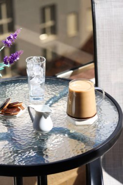 Sütlü bir fincan kahve ya da kurabiyeli sıcak çikolata ve yüksek kattaki bir kafede terasta bir bardak buz, şehir manzarası bulanık. Kahvaltınızı terasta yaparsınız.