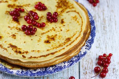 Açık mavi ahşap arka planda taze böğürtlenli leziz krepler, yakın plan, seçici odaklanma. Sağlıklı kahvaltı konsepti. Kırmızı üzümlü krep, lezzetli kahvaltı yemekleri.