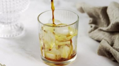 Bir bardak buzlu sade kahveye süt dökmek. Buzlu kahve kokteyli hazırlanıyor. Soğuk, ferahlatıcı kahve yapıyorum. Kremayı kıvrımlı bir bardağa doldurup kahveyle kapatın.