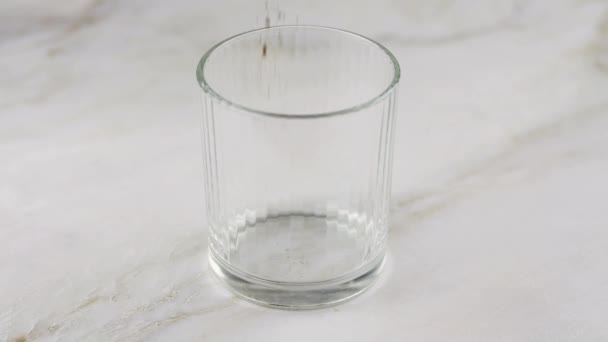 インスタントコーヒーをグラスに コーヒーパウダーからバロナコーヒーのための泡を準備する最初のステップ インスタントグラウンドコーヒー付き透明ガラスのクローズアップ — ストック動画