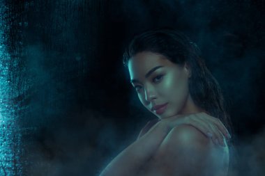 Göz kamaştırıcı bir kadının el ele tutuşup gece yıkanırken çekilmiş fotoğrafı koyu nemli cam arka planda izole edilmiş..