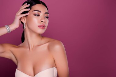 Kırmızı halı festivalinde fotoğrafçılara poz veren muhteşem bayan ünlünün fotoğrafı izole edilmiş pembe arka plan.