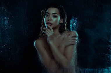 Kibar bayanın kendine sarılıp duş alırken çekilmiş fotoğrafı nemli camlı, koyu renkli arka planda izole edilmiş cilt sulandırıcı..