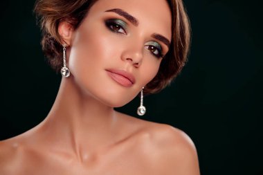 Nazik, güzel bir bayanın fotoğrafı. Makyaj hazır. Kırmızı halı olayı yeşil arka planda izole..