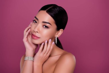 Göz kamaştırıcı, şık bir kadının portresi. Pembe arka planda soyulmuş cilt bakımına hazır olun..