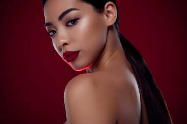 Klas rüya hanımefendinin fotografını kapat. Muhteşem görünüyor. Kestane rengi arka planda izole edilmiş şenlikli olay için makyaj yap..