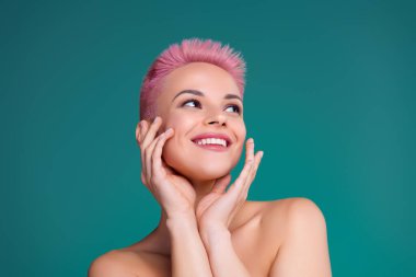 Stunning pink short hair young lady model touch facial skin enjoy new product skin care anti age wrinkle akne action.