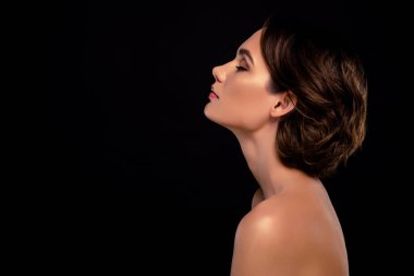 Kapalı gözlü, yarı çıplak vücutlu muhteşem bir yan portre. Siyah arka planda kendini baştan çıkarılmış hissediyor..