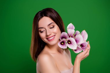 Yeşil bahar arkaplanından izole edilmiş Calia ile poz veren mükemmel görünümlü kadının stüdyo portresi.