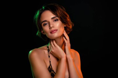 Yumuşak cildine krem sürmüş yumuşak bir kadın leopar desenli bikini mayo giyiyor..