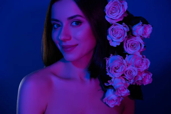 迷人的裸体女人拿着玫瑰束的照片 头发花瓣孤立 深蓝色 霓虹灯背景 — 图库照片