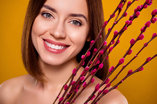 Closeup photo pretty girl prepare to celebrate Easter hold pink color willow tree branches bloom over yellow background.