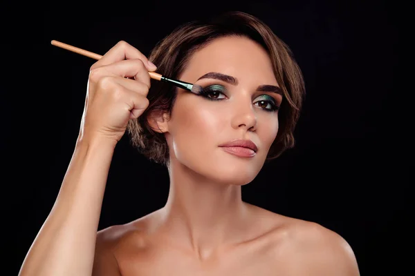 别致女士的画像准备晚间活动用毛刷眼影作为理想的深色背景化妆 — 图库照片