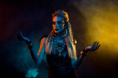 Portrait of mysterious enchant viking girl black magic ritual colorful lights fog isolated on black background. clipart