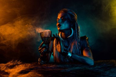 Tehlikeli Valkyrie Druid kadın portresi iksir bardağı tutun mavi ışık sisi siyah arkaplan izole.