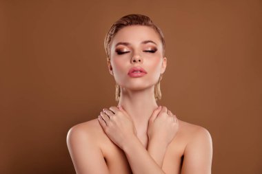 Parlak, tapılası, çıplak kadın, kendine sarılmış, kapalı gözler, izole edilmiş kahverengi arka plan..