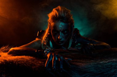 Korkunç kuzey mitolojisi fotoğrafçısı kara büyü ayini hayvan kürkü turuncu ışık sisi karanlık arka planda izole edilmiş..