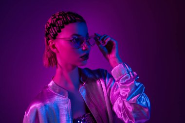 Şık modern bayan fotoğrafı. Profil yan dokunuş özellikleri. Neon ultraviyole arka plan üzerinden sinematik gece etkinliği..