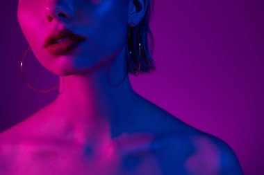 Çekici ve şık bir bayanın, neon arka plandaki fütüristik spa tedavisinden sonra keyifle çekilmiş fotoğrafı..