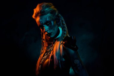 Ürkütücü şüpheli gizemli kadının fotoğrafı Viking giysileri giyip İskandinav tanrılarına koyu turuncu arka plan için dua ediyor..
