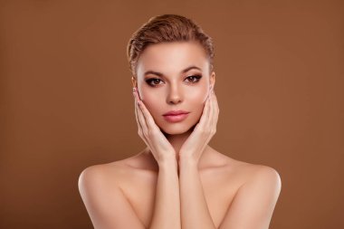 Güzel, güzel bir kadının çıplak kollarının yanaklara değdiği fotoğraf izole edilmiş krem rengi arka plan uyguluyor..