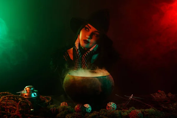梦幻般的巫婆在雾气弥漫的霓虹灯下煮煮开锅的爱情药水的照片 — 图库照片