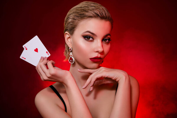 Photo of luxury successful woman wear black dress winning cards game isolated red ruby color background.
