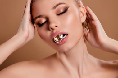 Çekici, zarif, ısırgan, kristal değerli taş küpelerin bej renkli arka planda izole edilmiş fotoğrafı..