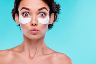 Şaşırmış kadının fotoğrafı hava öpücüğünü etkiledi. Mavi arkaplan üzerinde düzeltme bandı üstüne kusursuz saf ten..