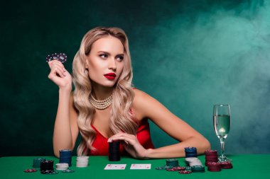 En iyi poker oyuncusuyla oynayan zarif, şık bir kadının fotoğrafı. Karanlık sisli arka planda servet yatırıyor..