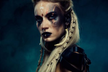 Close up photo of powerful viking queen princess with scar experienced fighter in north war over dark background. clipart