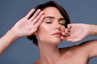 Nazik bayan dokunuşunun fotoğrafı yeni güzellik ürünü jeli sürerken gri arka planda yumuşaklığın tadını çıkar.