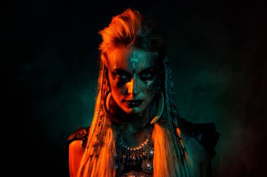 Havalı, korkunç, gizemli kadının fotoğrafı gotik Valkyrie kostümü giyiyor. Şüpheli görünüyor. Turuncu arka plan izole edilmiş..