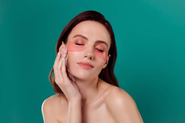 Güzel, genç bir bayanın portresi. Yanak bantlarına dokunur. Kişisel bakım günü spa salonu..