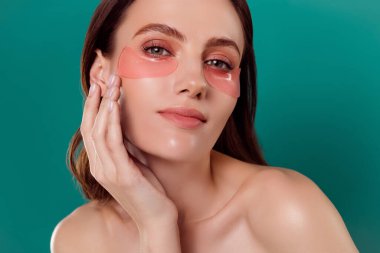Güzel bir genç kızın portresi. Yanak pedlerine dokunur. Günlük bakım spa salonu..