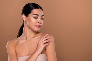 Bej renkli arka planda makyajsız fotoğrafçı pozu veren kız arkadaşının omzuna nazikçe dokunduğu portre..